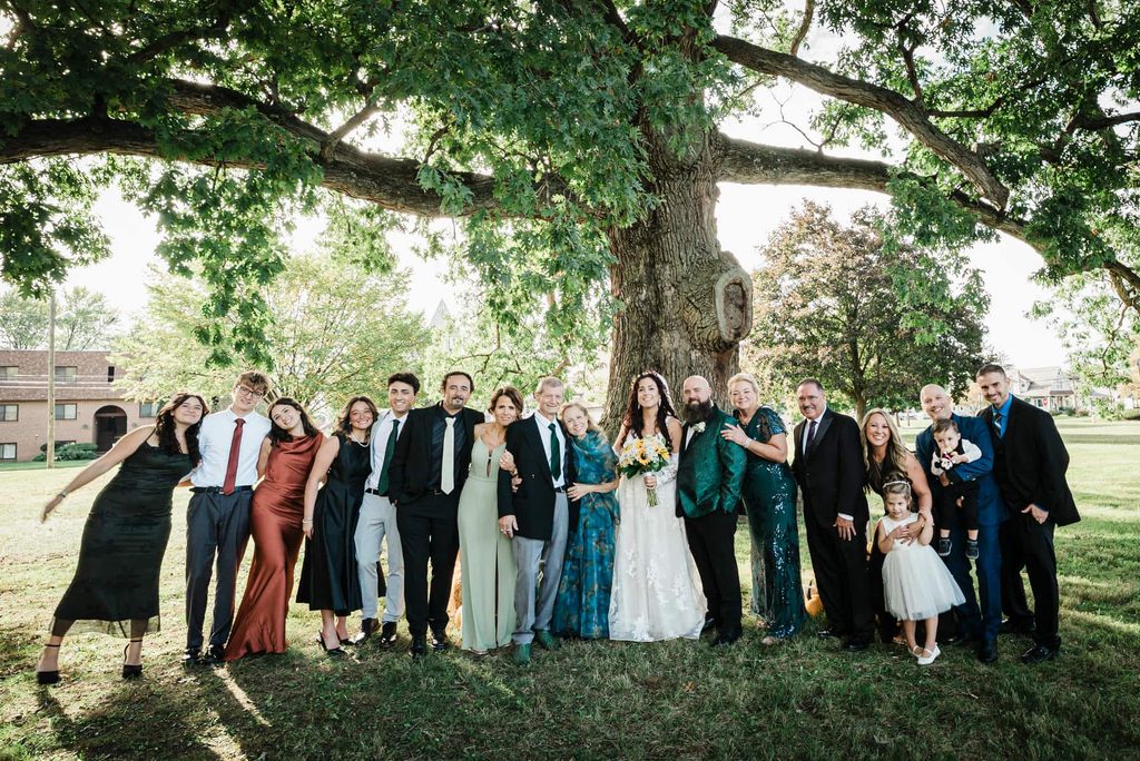 Wedding party and family gathered for a group portrait beneath the oak tree in Collingswood NJ
