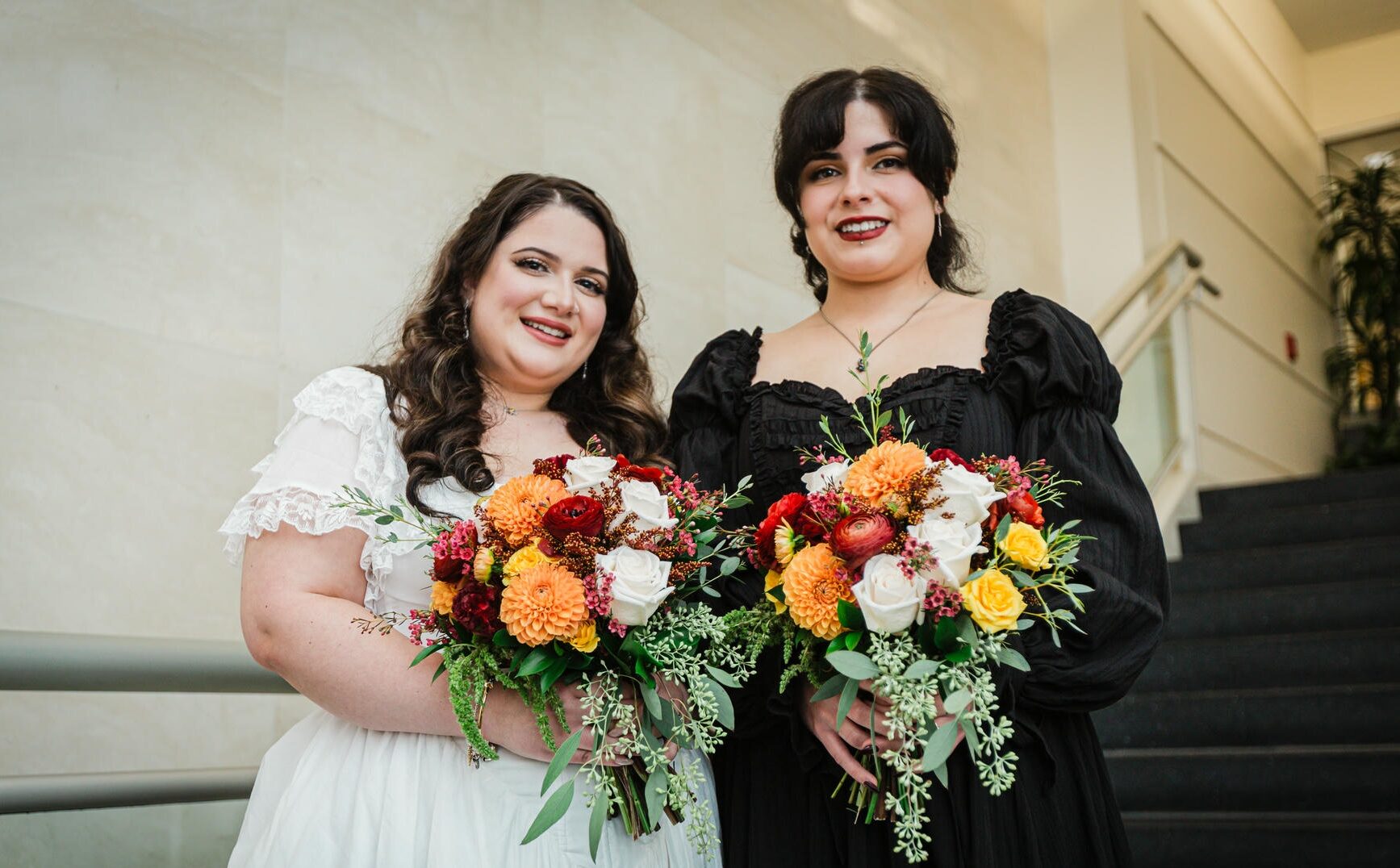Newlywed couple holding colorful bouquets after their courthouse wedding in Hackensack, NJ