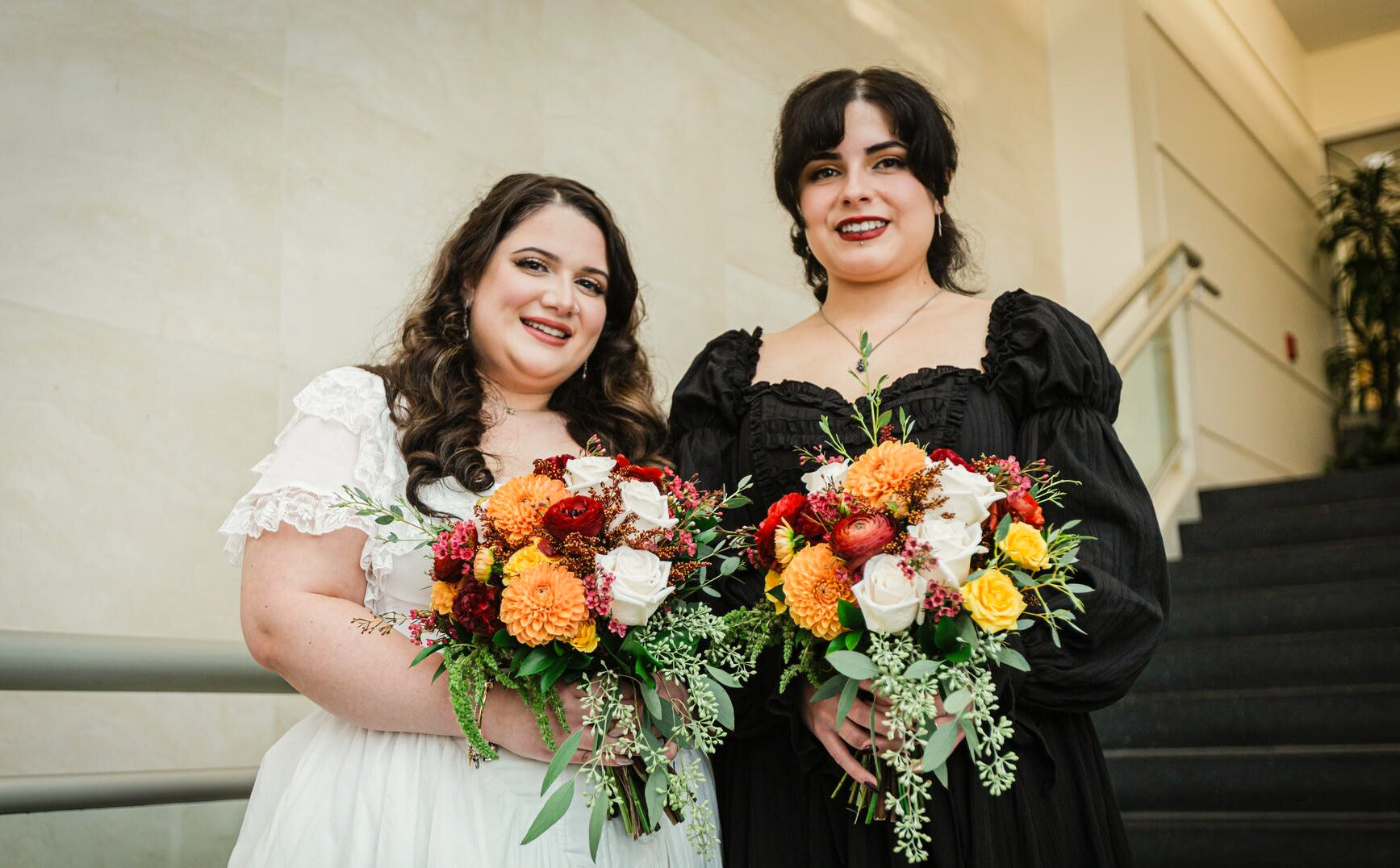 Newlywed couple holding colorful bouquets after their courthouse wedding in Hackensack, NJ
