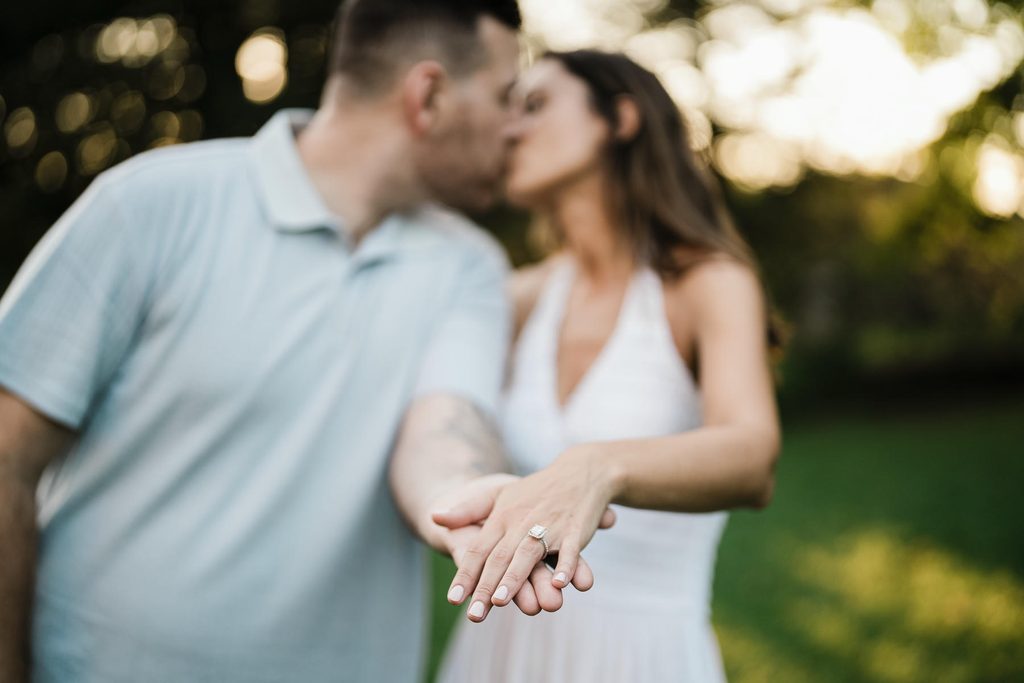 Jonathan and Emma kiss with her engagement ring in soft focus at Skylands Manor
