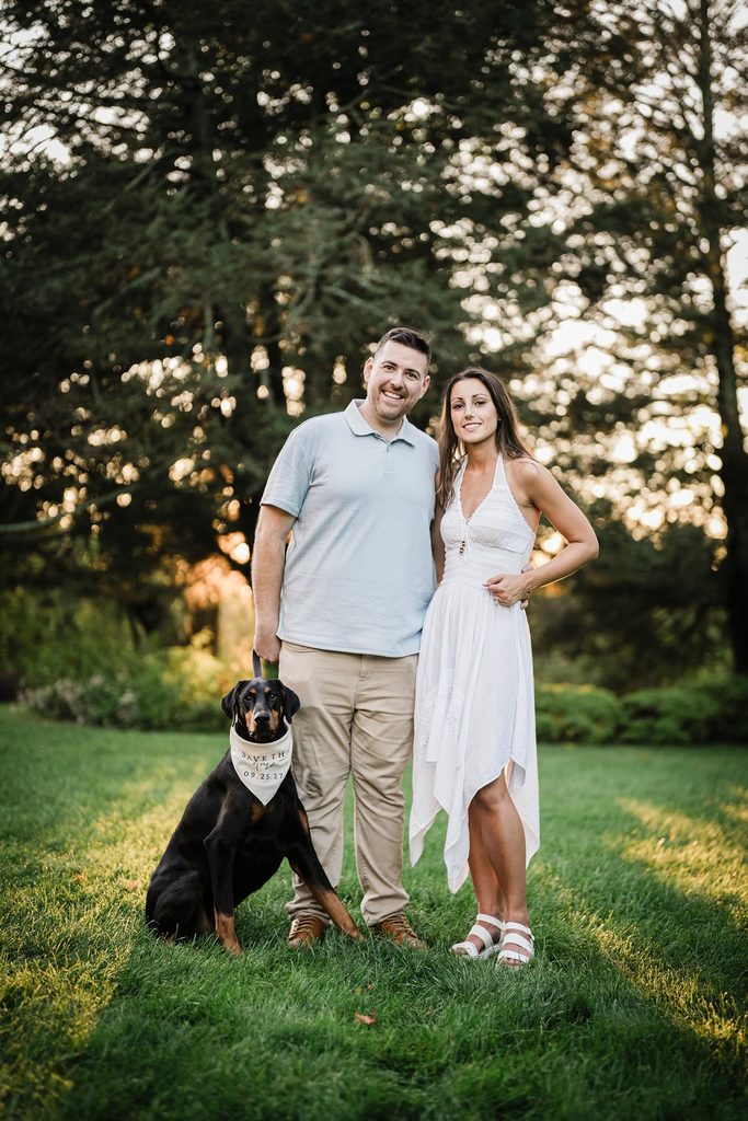 Jonathan and Emma standing together with their dog on the lawn at Skylands Manor