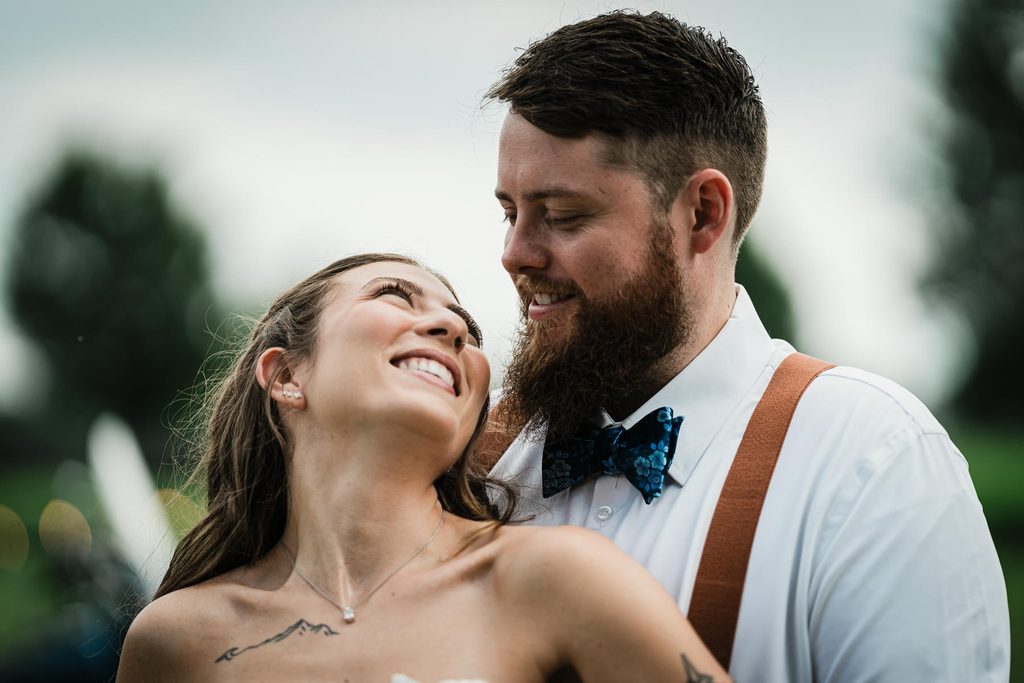 Bride and groom smiling together near motorcycles at their Franklin Township backyard wedding