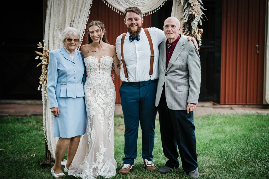 Couple posed with family members in front of a red barn in Franklin Township