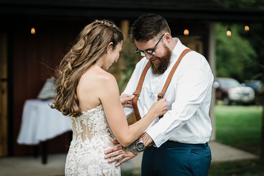 Bride and groom sharing a first look beside a red barn in Franklin Township
