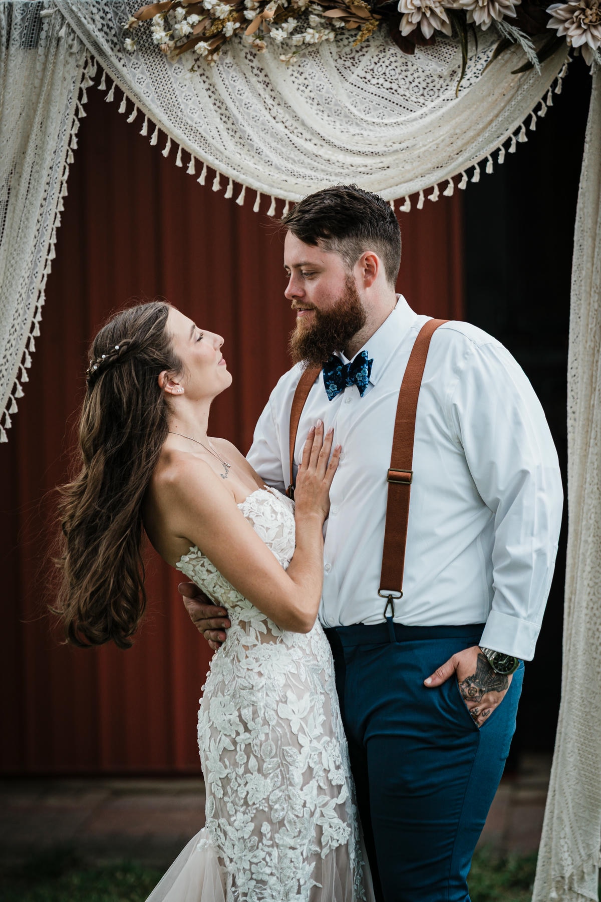 Bride and groom kissing beneath the ceremony arch at their Franklin Township backyard wedding