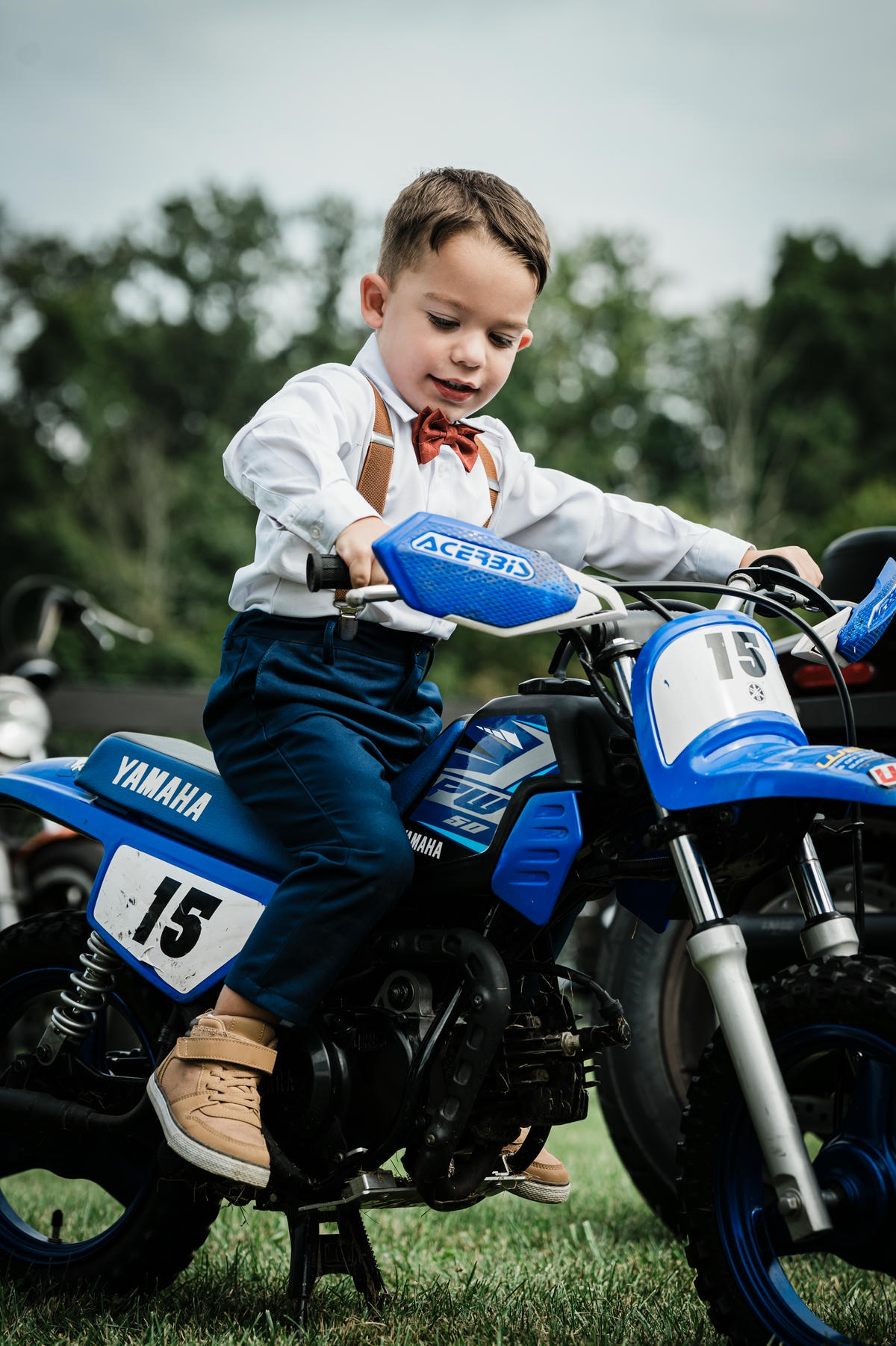 Young guest riding a small blue dirt bike on the lawn in Franklin Township