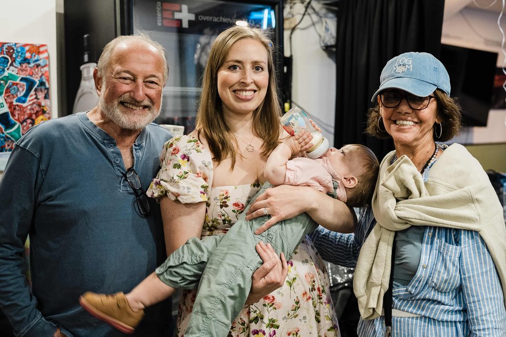 Guests posing with a mother and her baby during a birthday party at Crossbar NYC