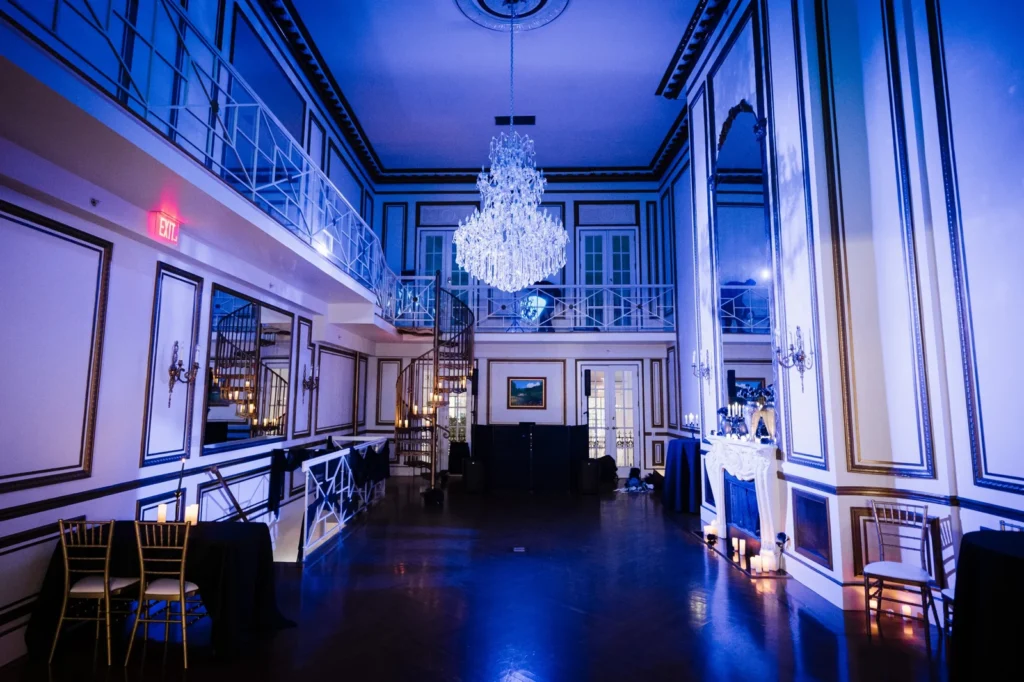 Blue-lit ballroom with crystal chandelier and candles at James Ward Mansion in Westfield NJ