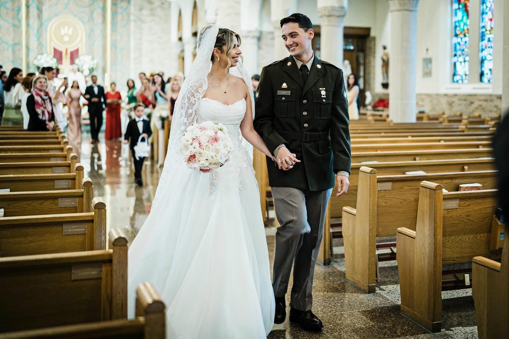 Newlyweds walking back down the center aisle at St. Gregory the Great Church