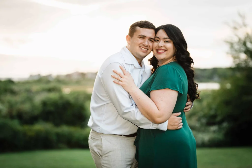 Engaged couple embracing with the salt marsh behind them at Harkness in Connecticut