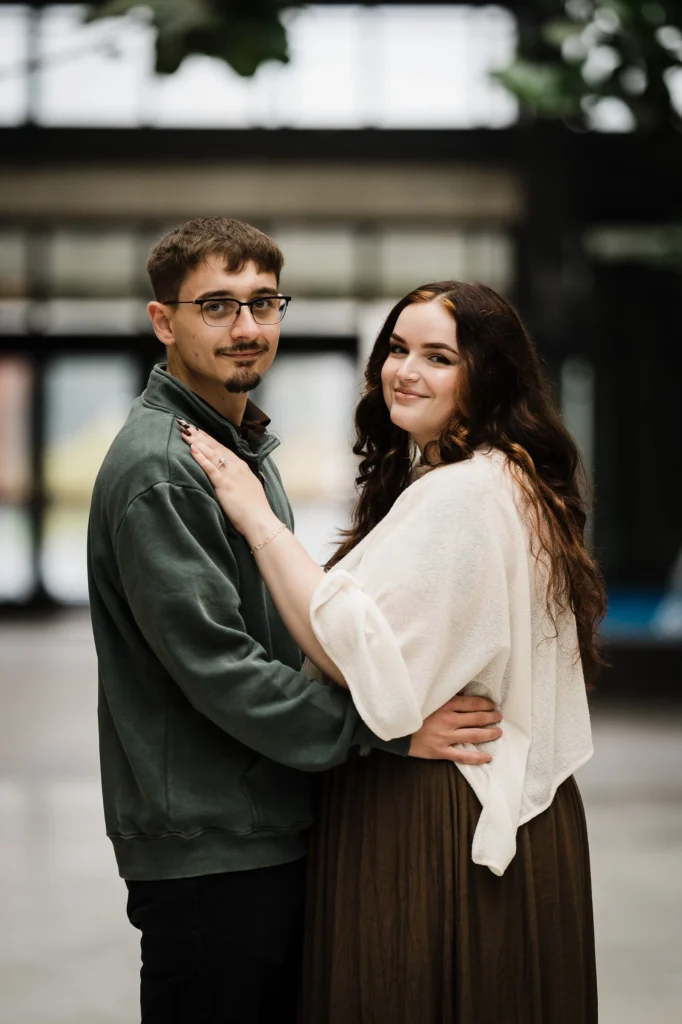 Samuel and Savannah smiling at each other inside the Bell Works atrium