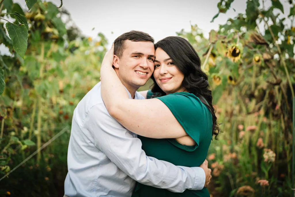 Engaged couple embracing among sunflowers in the Harkness Cutting Garden in Waterford