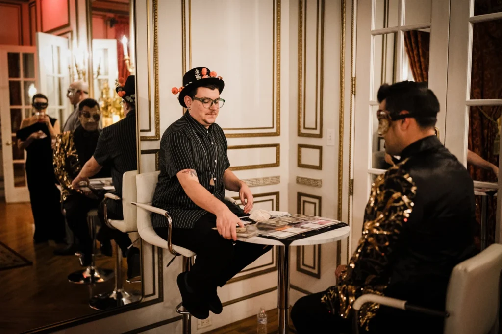 Tarot reader dealing cards for a masked guest in a mirrored room at James Ward Mansion