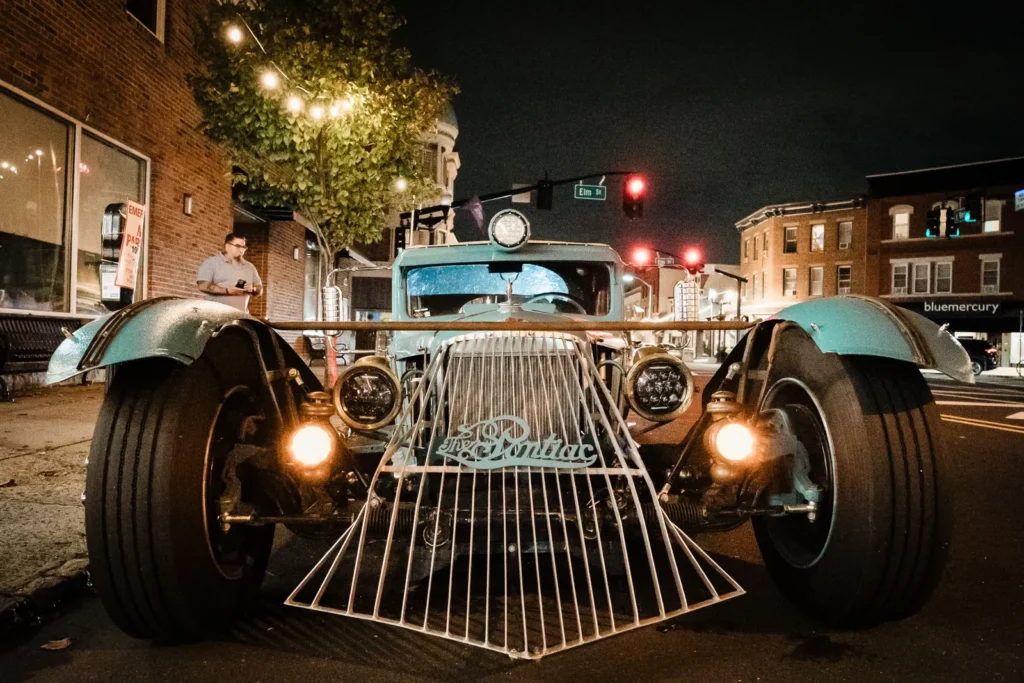 Vintage-style teal hot rod with chrome wheels parked outside James Ward Mansion in Westfield